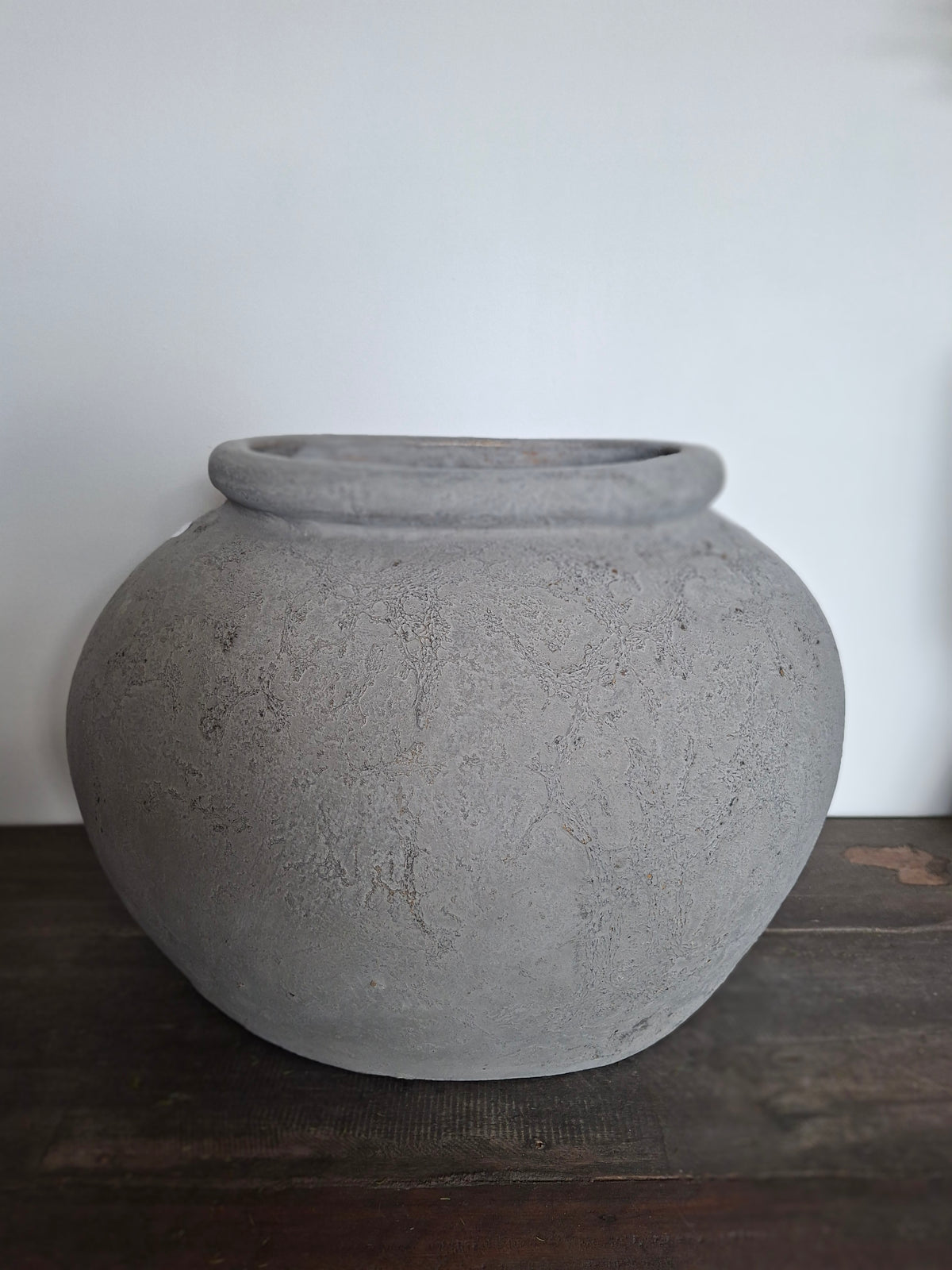 Brede grijze stenen pot met een klein werkje